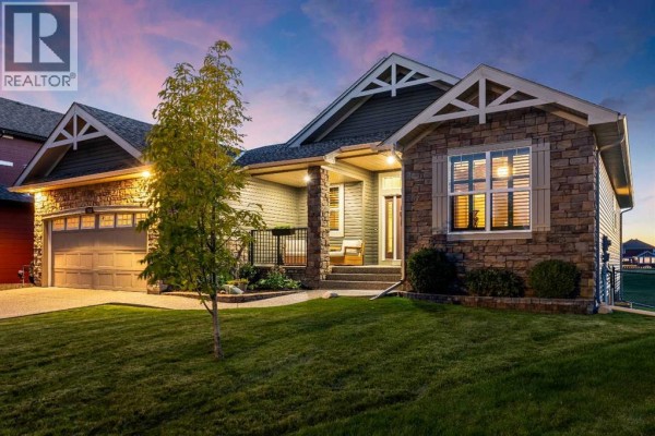 Front exterior of a residential house with stone and siding facade at dusk. - 517 Boulder Creek Circle Se, Langdon
