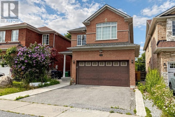 Another angle of the house exterior, highlighting the brickwork and landscaping with flowering bushes. - 517 Navigator Drive, Mississauga