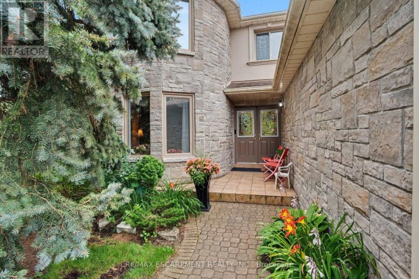 Close-up of the front entrance with a brick pathway, stone siding, and a double front door. - 5172 Hidden Valley Court, Mississauga