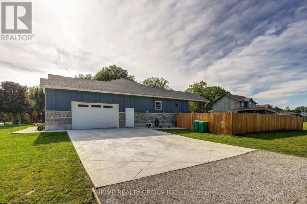 Rear exterior of the house showing a garage, driveway, and fenced backyard. - 5178 Glendon Drive, Southwest Middlesex