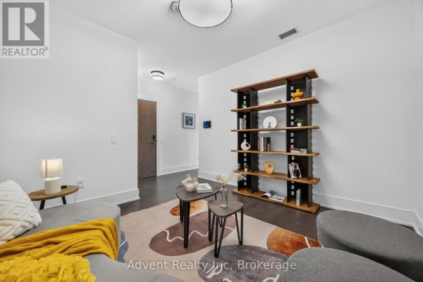 An empty room with white walls, dark wood floors, and a ceiling light. - 518 - 30 Inn On The Park Drive, Toronto