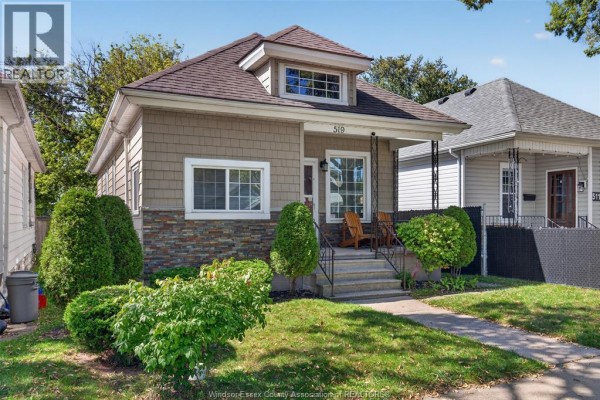 Front of the house with landscaping, showing the porch and living room window. - 519 Mckay, Windsor