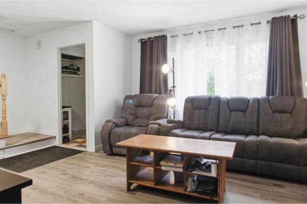 Wooden backyard deck with lush green trees and fencing surrounding the yard. - 519 Rue De Fribourg, Gatineau
