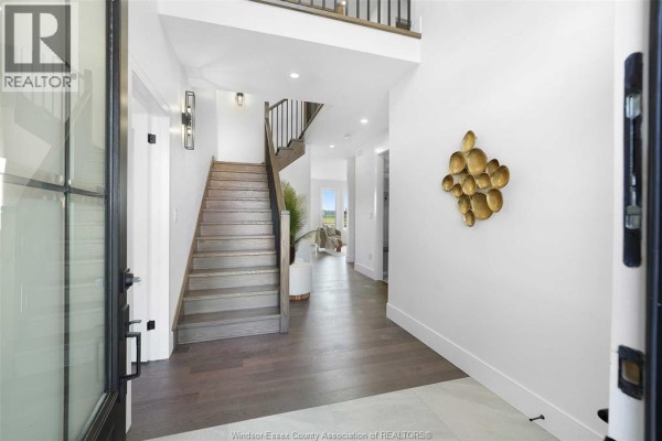 Modern living room with large windows, fireplace, and contemporary furniture - 5197 Rafael, Tecumseh
