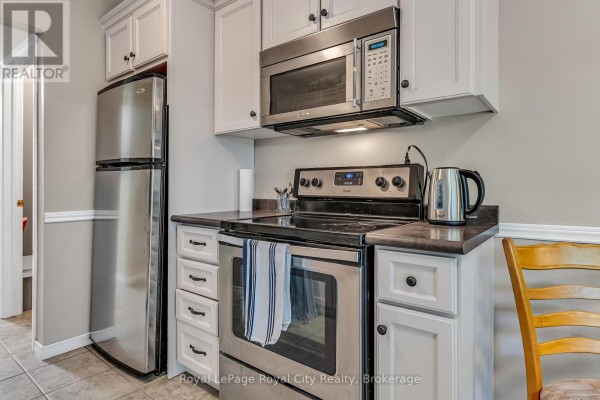 Stainless steel refrigerator and stove with white cabinets in a kitchen area. - 52 - 16 Hadati Road, Guelph