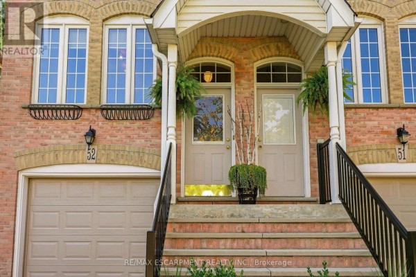 Close-up of the townhouse entrance with two doors, brick facade, and stone steps. - 52 - 3480 Upper Middle Road, Burlington