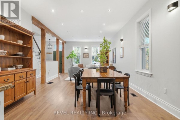 Dining room with wooden table, hutch, and open-concept living area - 52 Cambridge Street N Kawartha Lakes