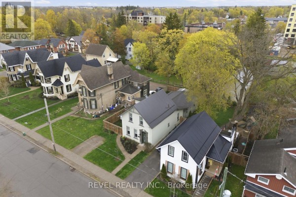 Aerial view of street with multiple houses, trees, and new roofs - 52 Cambridge Street N Kawartha Lakes