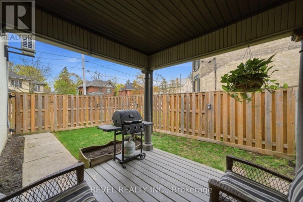 Covered deck with grill and outdoor seating overlooking grassy yard - 52 Cambridge Street N Kawartha Lakes