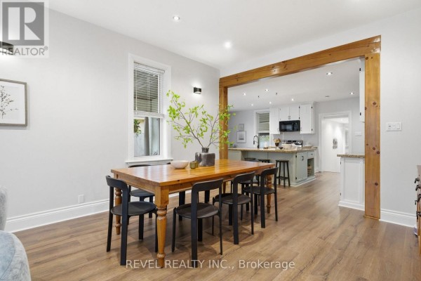 Wooden dining table with black chairs and kitchen island - 52 Cambridge Street N Kawartha Lakes