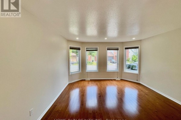 Living room with a bay window, hardwood floors, and recessed lighting. - 52 Collington Street, Ottawa