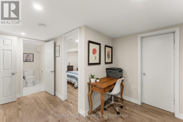 Hallway with a desk, printer, and doorways to a bathroom and bedroom. - 52 Concession Road, Kawartha Lakes