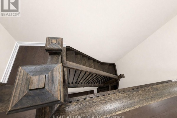 View from above looking down a dark wood staircase with detailed square newel posts and black spindles. - 52 Heming Trail, Hamilton