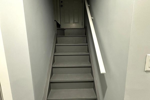 Interior view of a dark grey staircase with a white handrail, leading upwards. - 52 Herefordshire Crescent, Newmarket