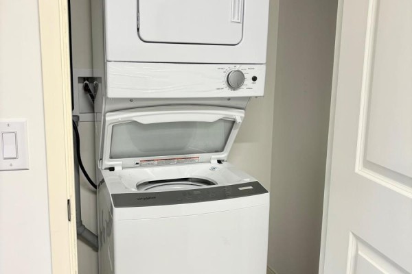 Stacked white washing machine and dryer in a closet. - 520 - 135 Station Street, Belleville