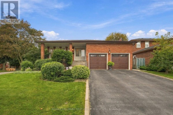 Front view of the house featuring a double garage and snow-covered landscape. - 520 Mcleod Crescent, Pickering