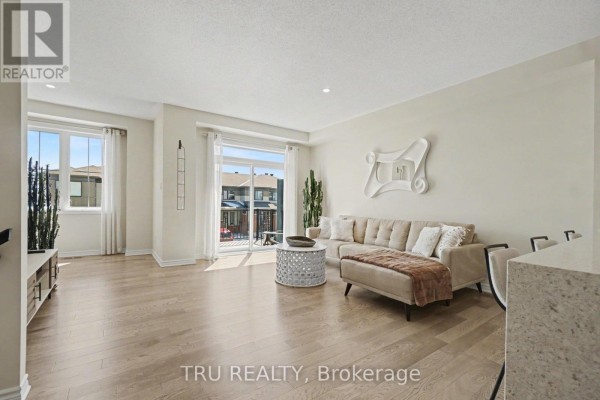 Empty room with a window, television, and a door to a hallway. - 520 Rye Grass Way, Ottawa
