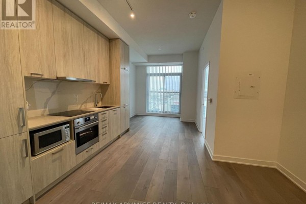 Kitchen area with light wood cabinets, stainless steel appliances, and wood floors. - 521 - 10 Honeycrisp Crescent, Vaughan