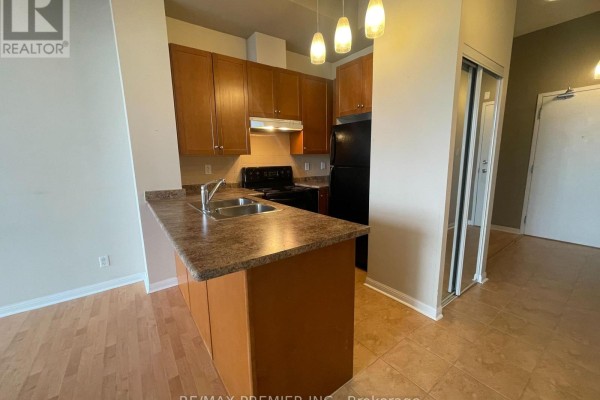 Compact kitchen with wood cabinets, laminate countertops, black appliances, and island. - 521 - 1600 Keele Street, Toronto