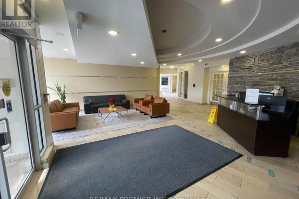 Building lobby with a reception desk, seating area, and stone accent wall. - 521 - 1600 Keele Street, Toronto