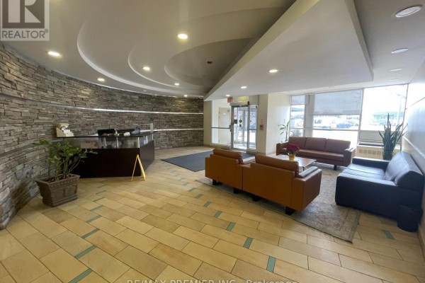 Building lobby with a reception desk, seating area, and stone accent wall. - 521 - 1600 Keele Street, Toronto