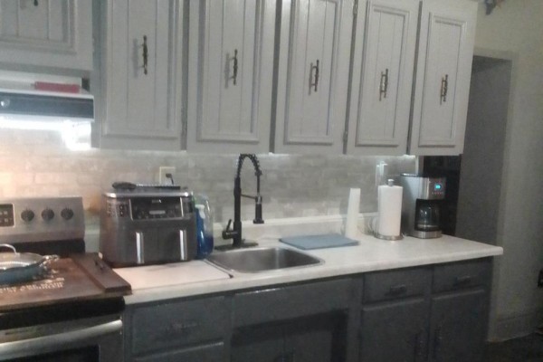 Dining area with a white table and chairs next to a white refrigerator and a doorway. - 521 Barton Street E, Hamilton