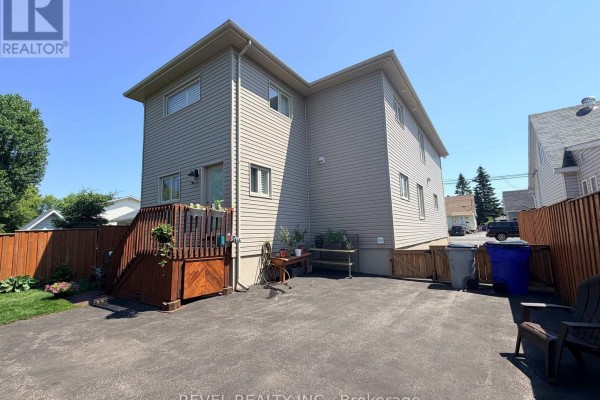 Detached garage with a snow-covered roof, located on a paved driveway. - 521 Pine Street N, Timmins