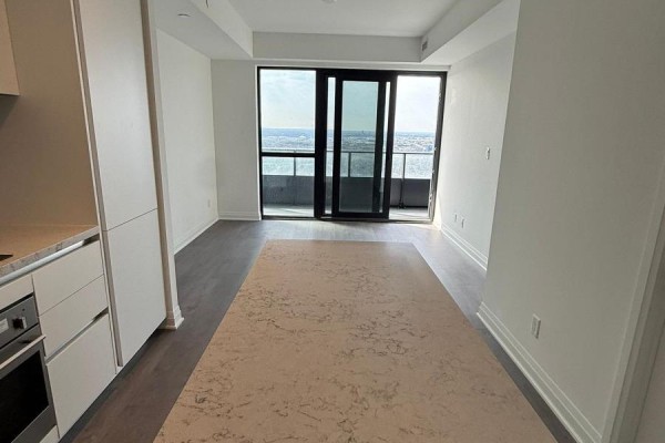 Open concept living area with island, large balcony doors, and city view. - 5210 - 4015 The Exchange, Mississauga