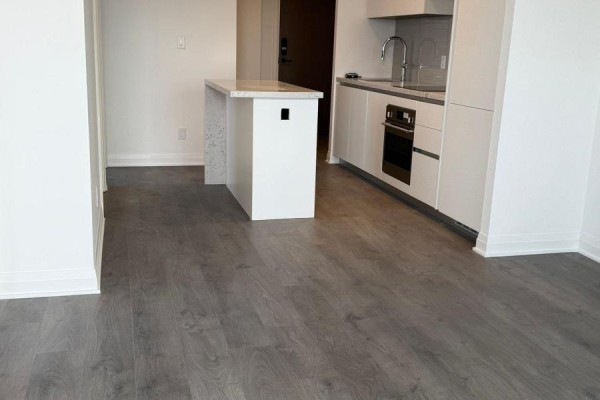 View of the kitchen island and grey wood-look laminate flooring. - 5210 - 4015 The Exchange, Mississauga