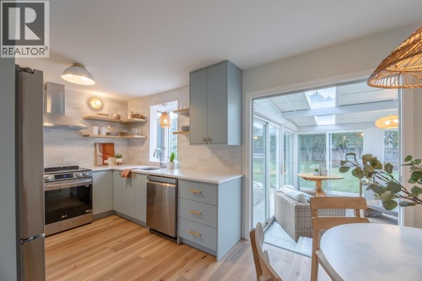 View of kitchen with dining area, featuring large windows and natural light. - 5214 Nixon Road, Summerland