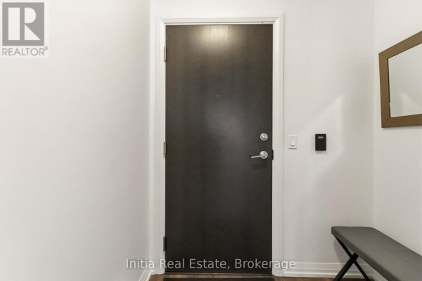 Close-up of a dark front door with a brushed nickel handle and a small bench. - 522 - 55 Ann O'reilly Ann O'reilly Road, Toronto