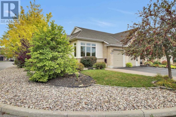 Corner view of the townhouse with manicured landscaping and a gravel base. - 522 Silverbell Crescent, Ottawa
