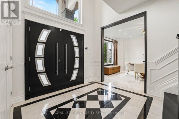 Interior foyer with black and white checkered marble floor, grand double doors, and view into a dining room. - 523 Kochar Drive, Ottawa