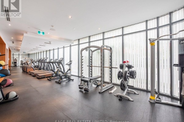 Gym with treadmills, weight machines, and free weights next to large windows. - 524 - 38 Cameron Street, Toronto