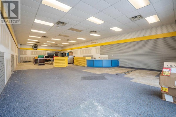 Interior view of an empty commercial space with blue and yellow accents and fluorescent lighting. - 524 Great Northern Rd # 3, Sault Ste  Marie