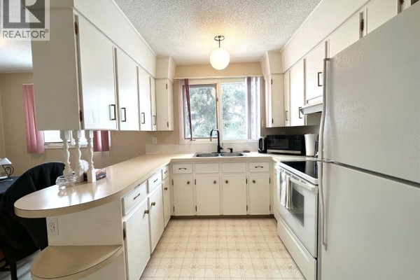 Bathroom vanity with a double sink, mirror, and a row of lights. - 5240 50 Avenue, Holden