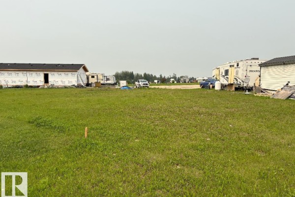 Open grassy area with a foundation being constructed, RVs parked nearby. - #525 454029 Rge Road 11, Rural Wetaskiwin County