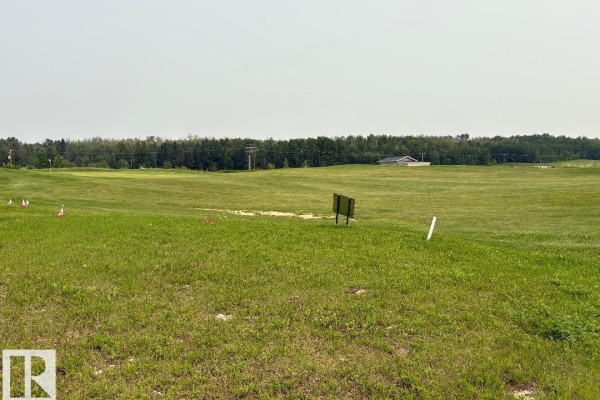 A wide view of a green golf course with trees and utility poles in the background. - #525 454029 Rge Road 11, Rural Wetaskiwin County
