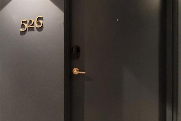 Close-up of a dark gray apartment door with gold numbers '526' and handle. - 526 - 543 Richmond Street W, Toronto