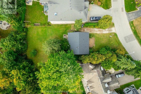 Overhead view of a rectangular detached garage with a grey roof surrounded by green lawn and trees. - 526 Stafford Drive, Oakville