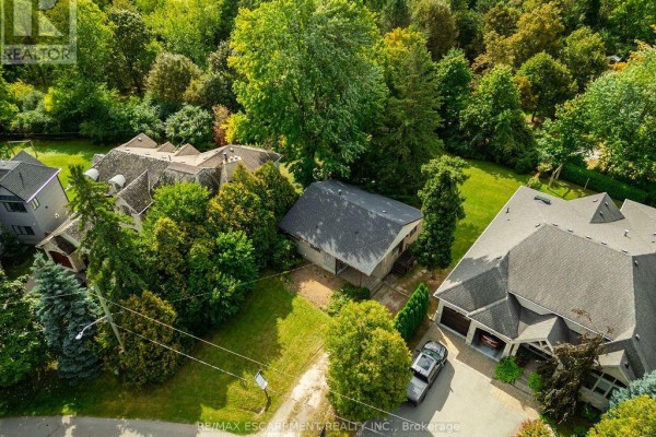 Aerial view of a property featuring a detached garage and a large house with a stone facade. - 526 Stafford Drive, Oakville