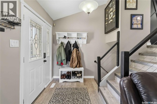 Living room with a leather couch, a coffee table, a television, and a brick fireplace. - 526 Tobin Crescent, Saskatoon