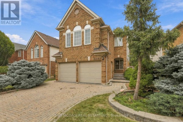 Front exterior of a two-story brick house with a double garage and landscaping. - 5263 Russell View Road, Mississauga