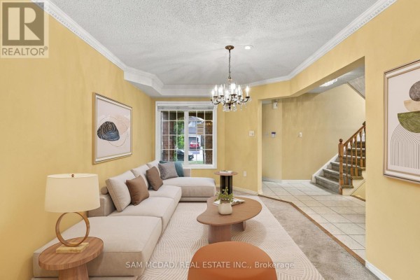 Living room with a sectional sofa, coffee table, and yellow walls. - 5263 Russell View Road, Mississauga