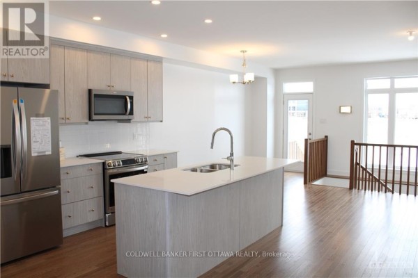 Modern kitchen with stainless steel appliances, white countertops, and an island. - 527 Corretto Place, Ottawa