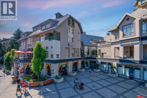 Exterior view of Blackcomb Way buildings with shops, balconies, and public plaza. - 528 4295 Blackcomb Way, Whistler