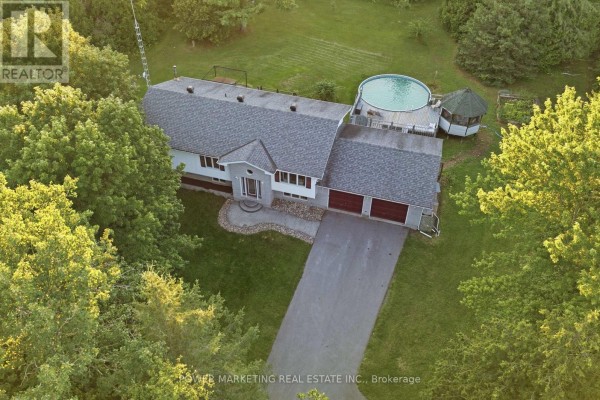 Aerial view of the property with a raised bungalow, driveway, double garage, above-ground pool, and gazebo. - 528 Kings Creek Road, Beckwith