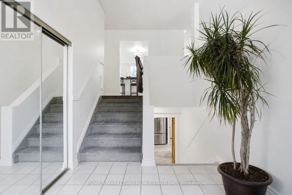 Interior entryway with a tiled floor, carpeted stairs leading up, a large mirrored closet, and a potted plant. - 528 Kings Creek Road, Beckwith