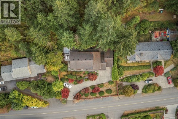 Aerial view of the house, driveway, and surrounding forested property. - 5287 Lost Lake Rd, Nanaimo