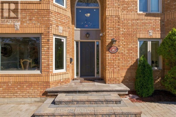 Close-up view of the front entrance with a dark grey door, transom window, and brick facade. - 5289 Fallingbrook Drive, Mississauga